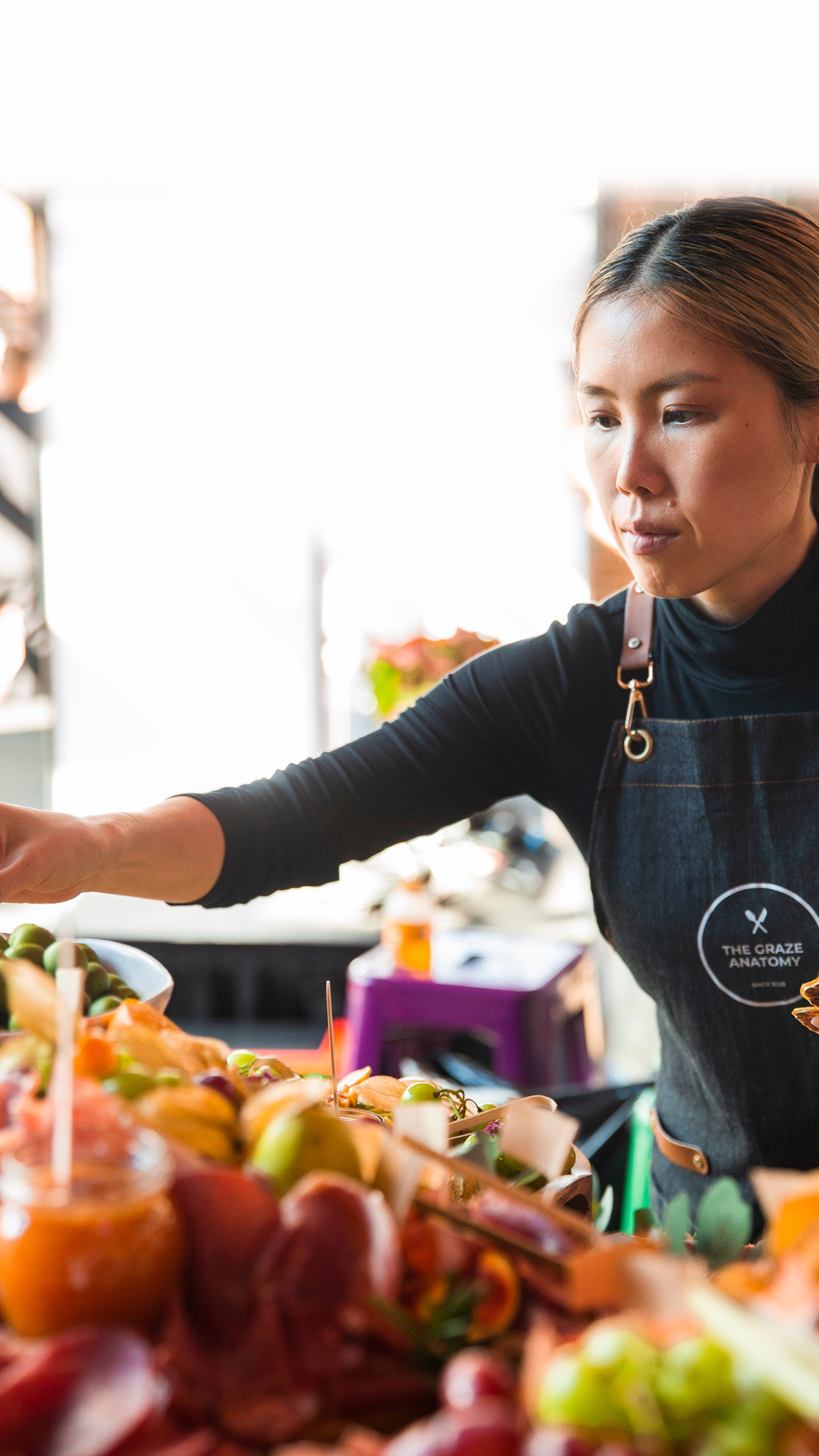 Portrait shot of Sophia Cong, founder of The Graze Anatomy creating a charcuterie grazing table in Toronto for a marketing launch.