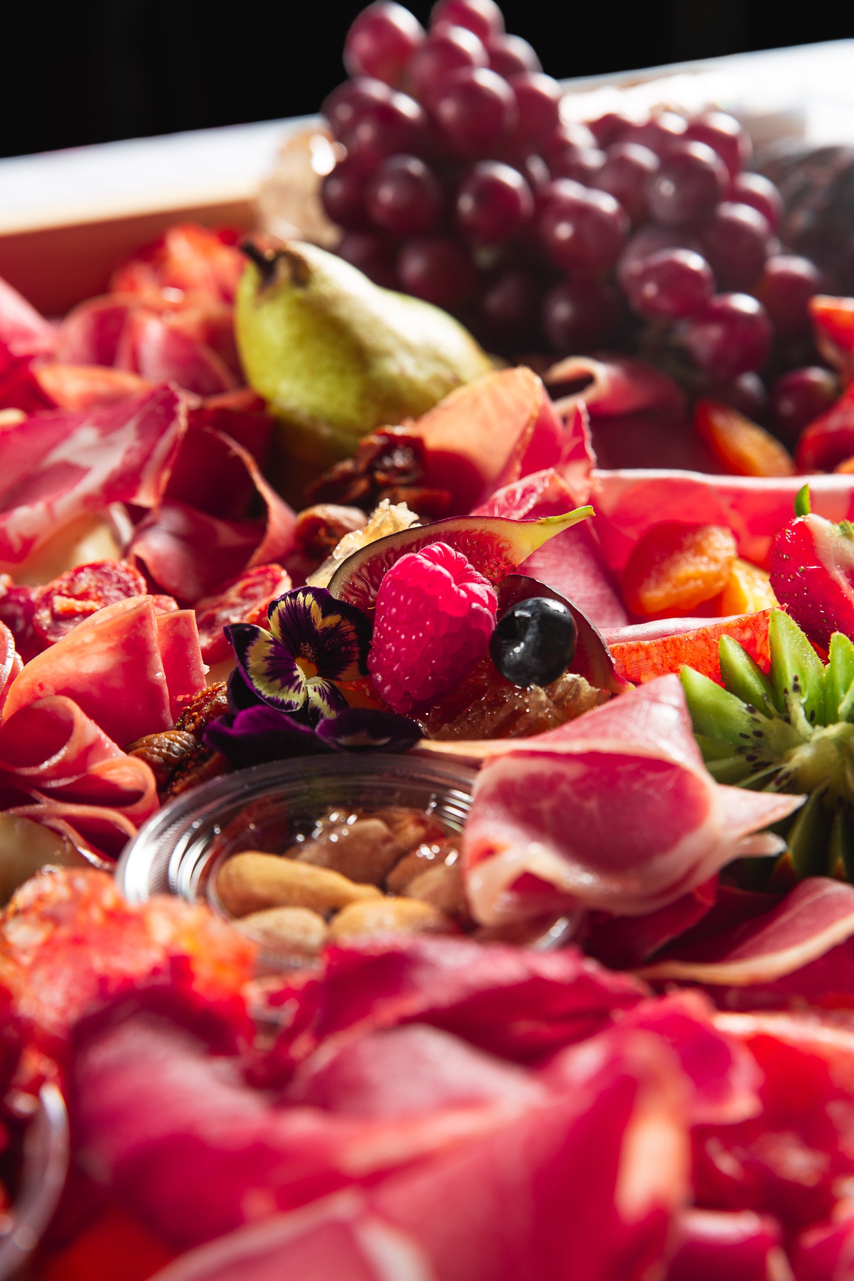 Closeup of fruit on charcuterie board by The Graze Anatomy