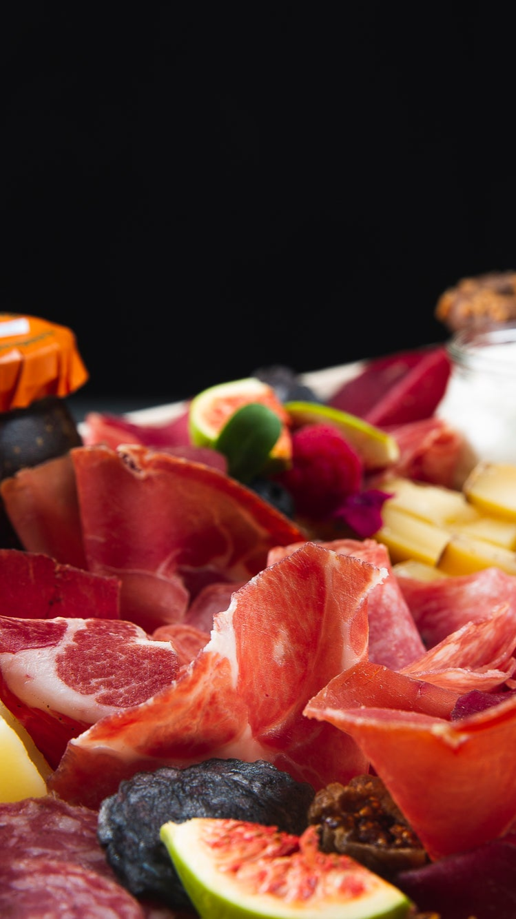 Close up of charcuterie board with cheese, fresh fruit, and slices of charcuterie in Toronto by The Graze Anatomy - charcuterie boards Toronto