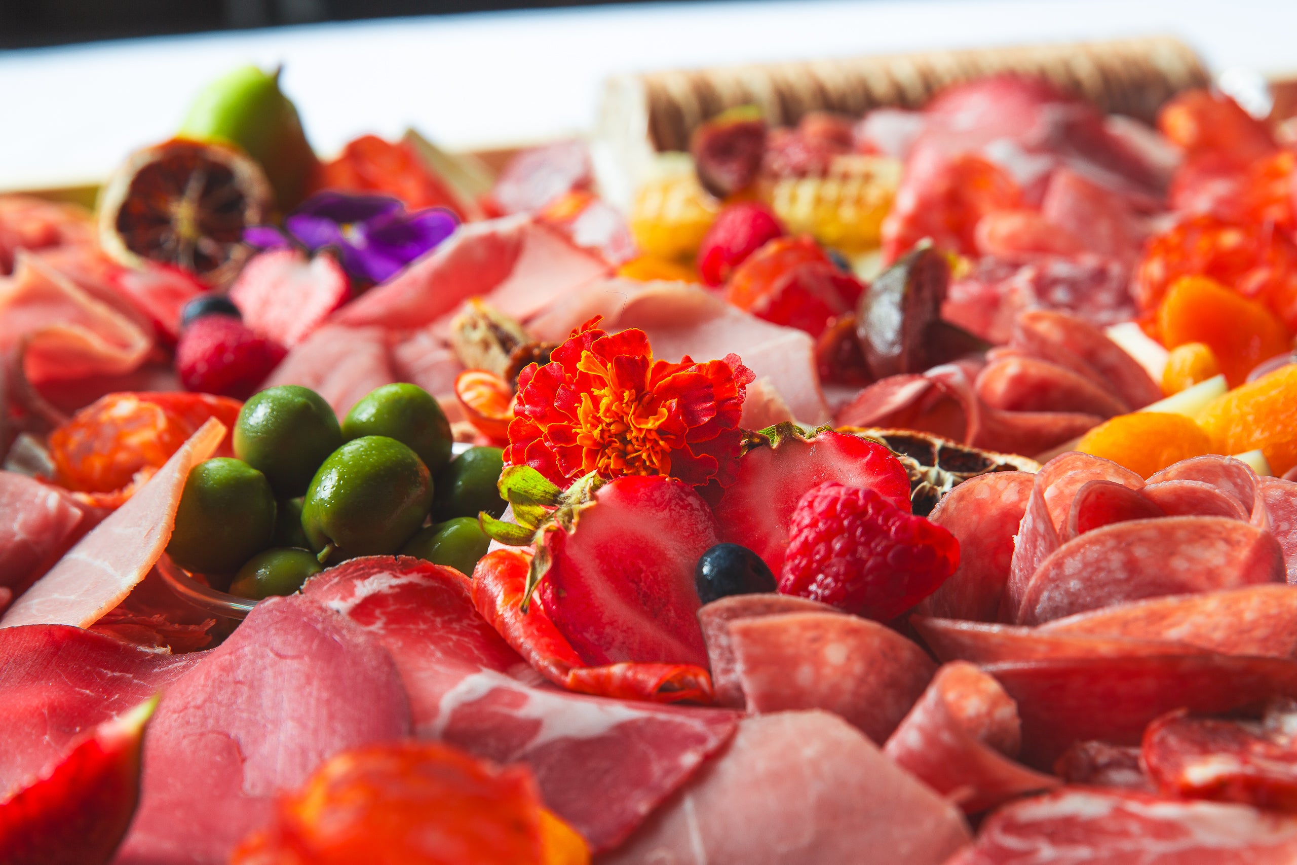 Platter of assorted charcuterie, cheeses, and fruits with a close-up view. For delivery in Toronto